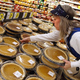 Grocery store worker stocking Thanksgiving pumpkin pies